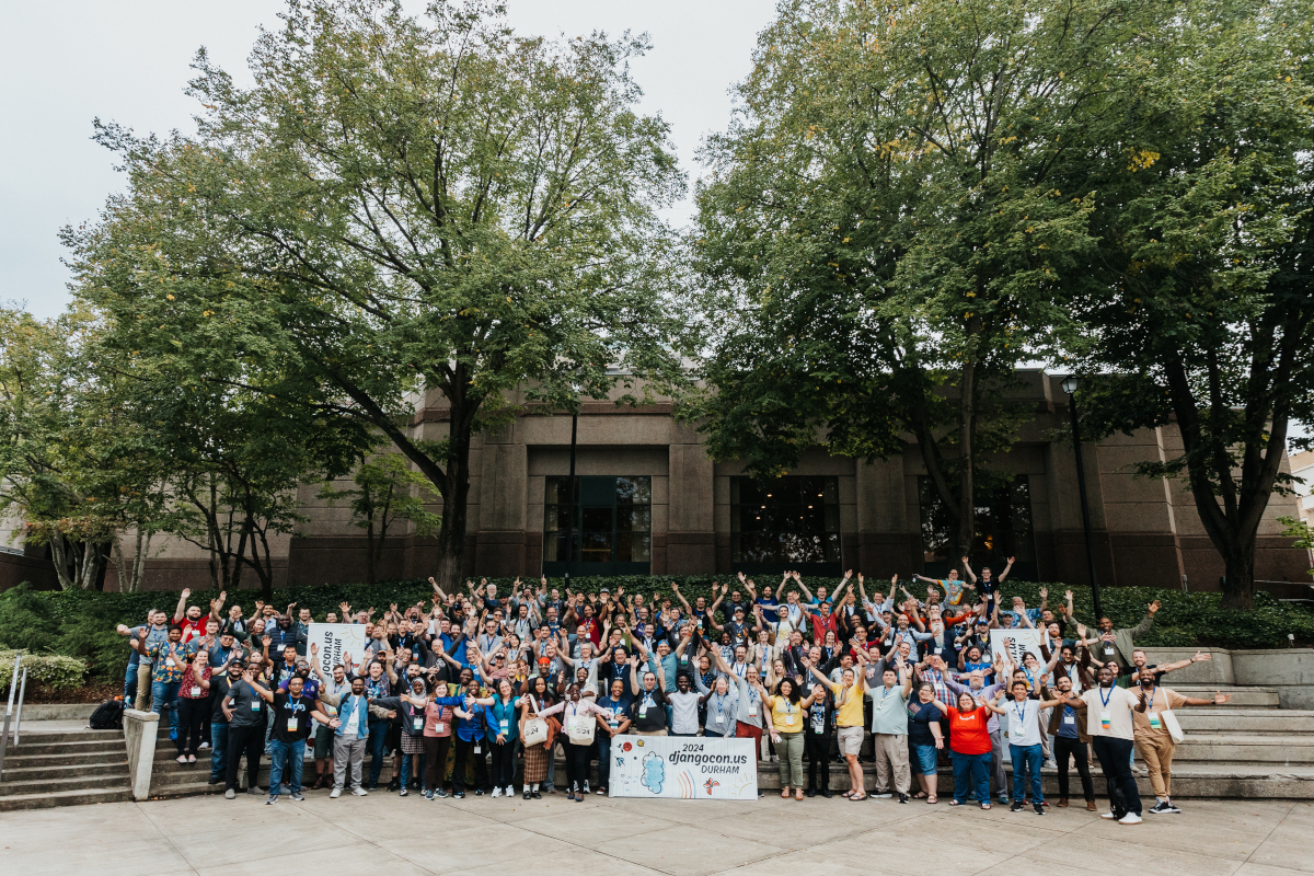 The DjangoCon US 2024 attendees welcoming everyone to Durham, NC! It's hundreds of people standing with their arms extended outwards.